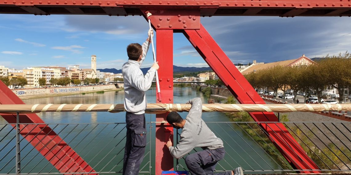 📷 Joves que aprenen l’ofici repinten el pont roig de Tortosa i eliminen pintades i grafits