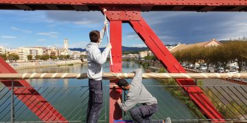 📷 Joves que aprenen l’ofici repinten el pont roig de Tortosa i eliminen pintades i grafits