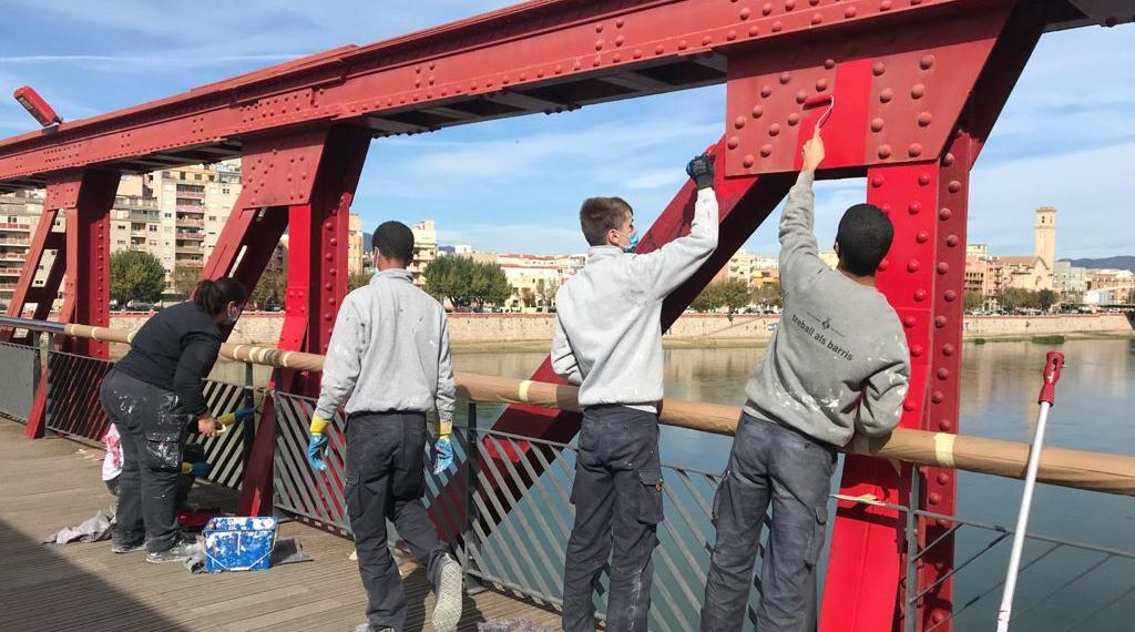 📷 Joves que aprenen l’ofici repinten el pont roig de Tortosa i eliminen pintades i grafits