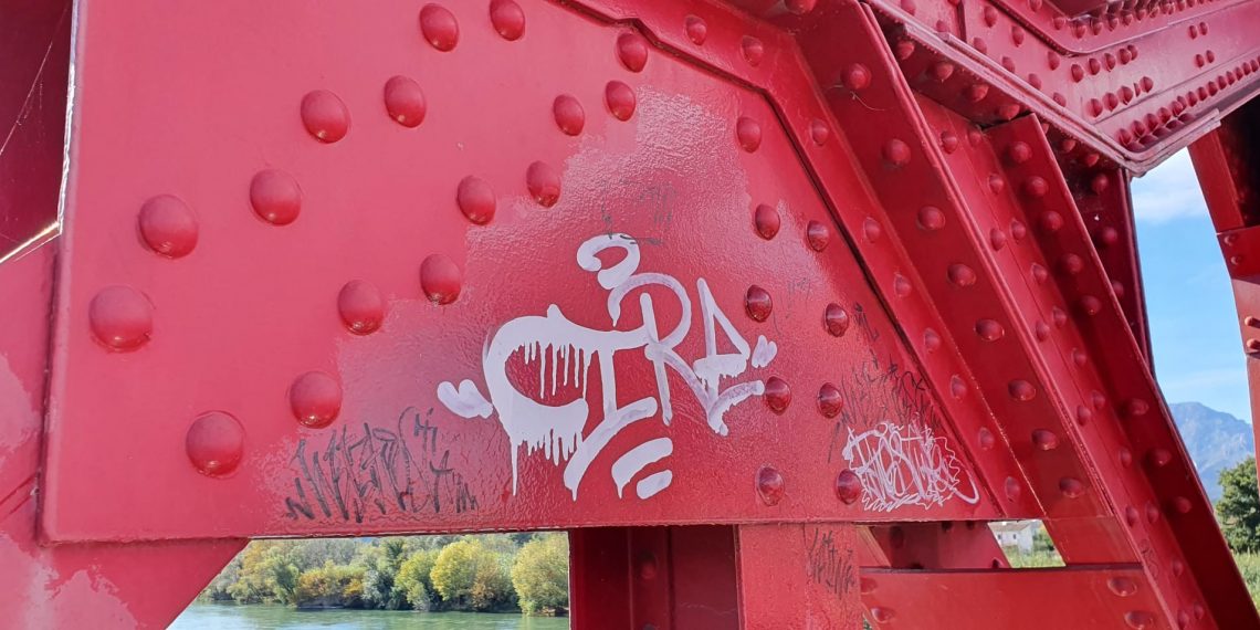📷 Joves que aprenen l’ofici repinten el pont roig de Tortosa i eliminen pintades i grafits
