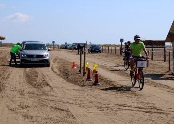 Vehicles i ciclistes accedint a la platja del Trabucador en el primer dissabte de la nova regulació. // ACN.