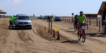 Vehicles i ciclistes accedint a la platja del Trabucador en el primer dissabte de la nova regulació. // ACN.