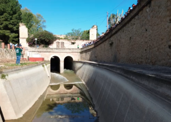 Els regants de l’esquerra solten l’aigua del canal amb l’alumnat de Camarles