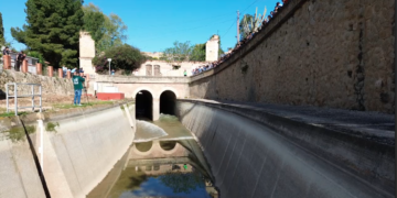 Els regants de l’esquerra solten l’aigua del canal amb l’alumnat de Camarles